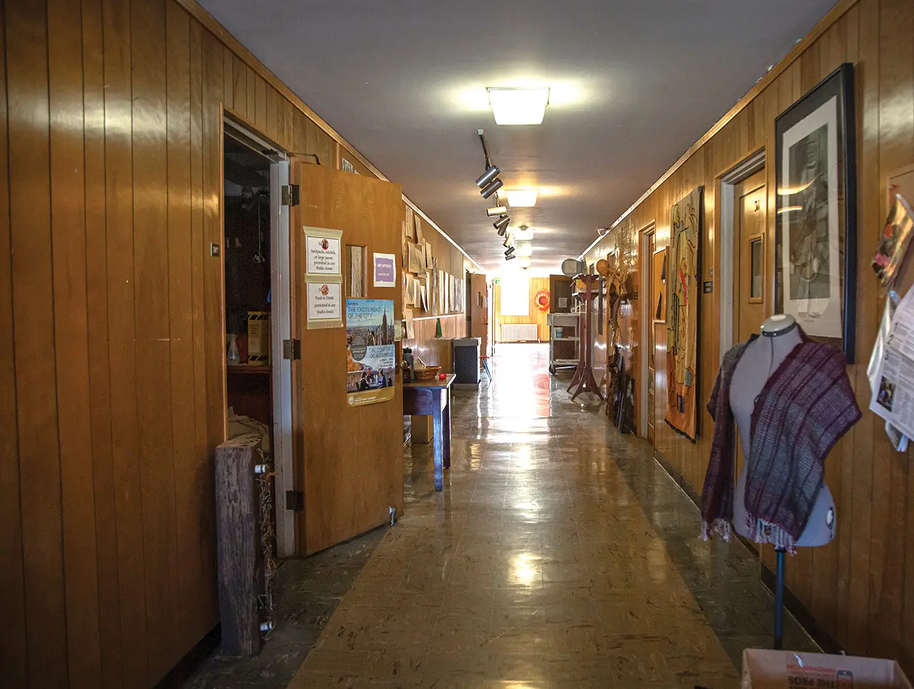 Long hallway with wood paneling walls and pictures
