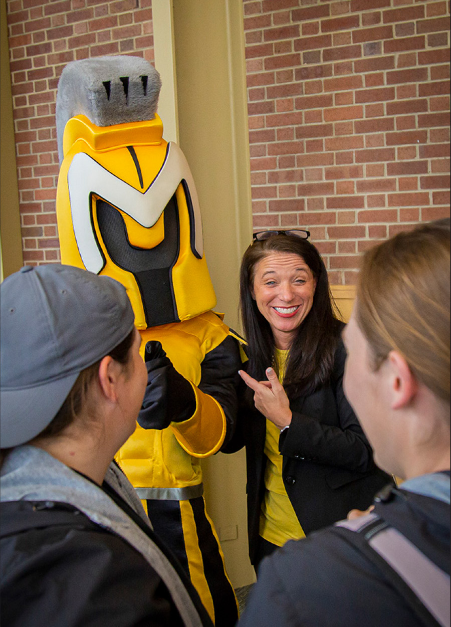 Stacey Horner with students and mascot