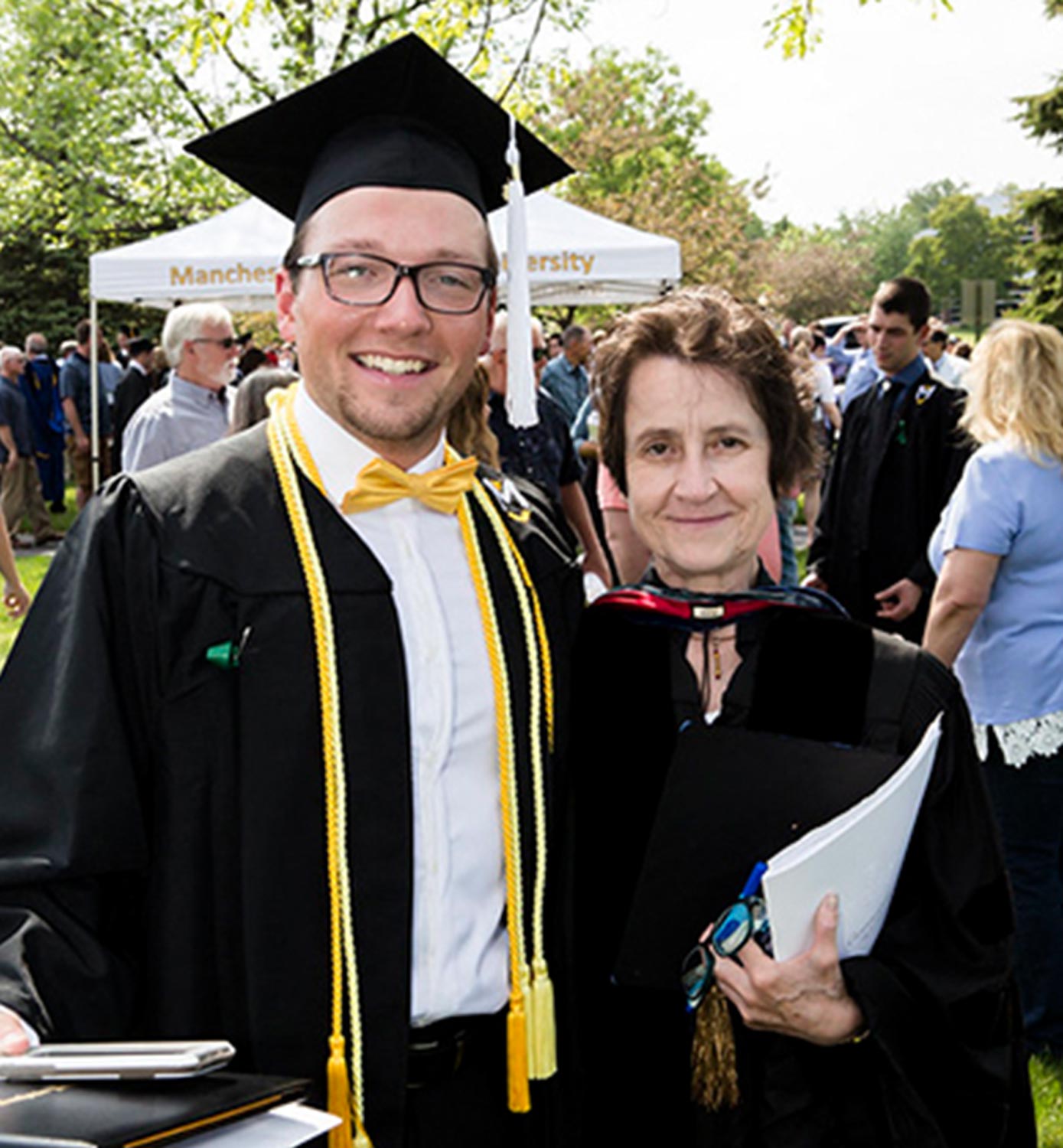 Beate Gilliar, wearing faculty robes, stands with Peter Shepherd wearing robes and a cap